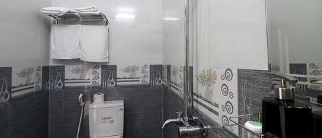 Un baño moderno con ducha, inodoro y lavamanos con vidrio.
