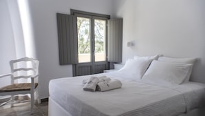 Une chambre à coucher avec un lit, une chaise et une fenêtre avec des volets.