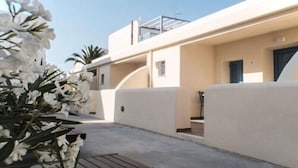 Un bâtiment moderne doté d’un toit plat, d’un balcon et d’une porte.