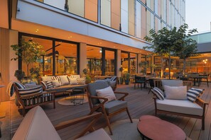 Un espace extérieur aménagé avec du mobilier en bois et des plantes en pot.