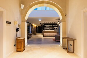 A hotel lobby with an arched ceiling, a reception desk, a wooden cabinet, and a seating area. - Hotel Indigo Larnaca by IHG (Larnaca)