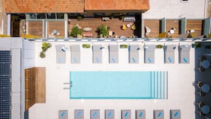 A rooftop pool with sun loungers and a wooden deck area. - Hotel Indigo Larnaca by IHG (Larnaca)