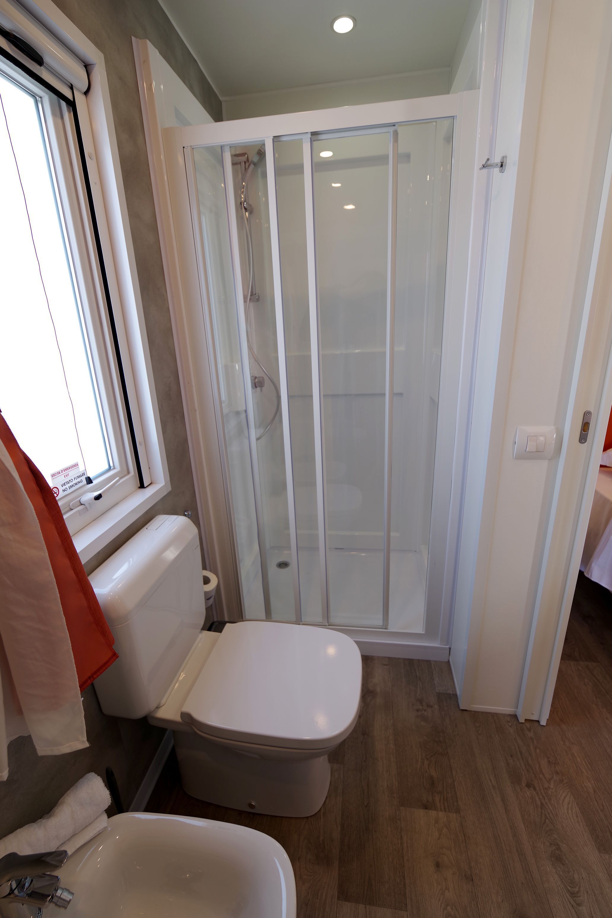A bathroom with a toilet, a sink, and a glass-enclosed shower.