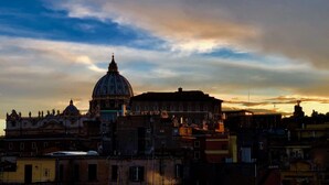 A historic building with a prominent dome, surrounded by urban structures. - Art Atelier Vaticano (Rome)