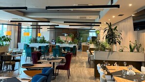 Ein modernes Restaurant mit Holzboden, mehreren Essplätzen und Stühlen.