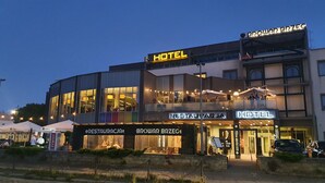 Ein Hotel mit Restaurant und einem separaten Restaurant namens 'RESTAURACJA' im Erdgeschoss.