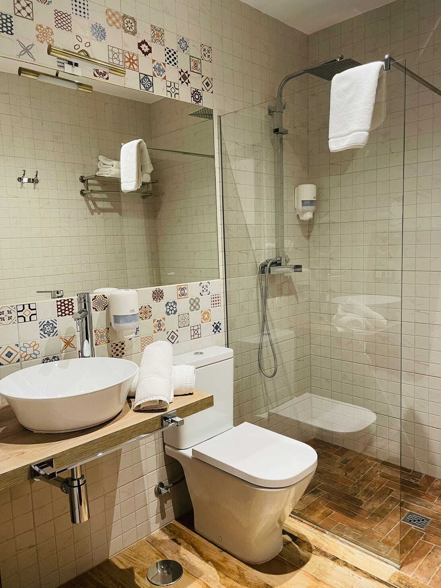 Een moderne badkamer met een vrijstaand bad, een wastafel en een toilet.