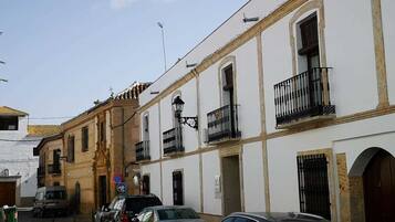 A narrow street with buildings featuring balconies and a mix of architectural styles.