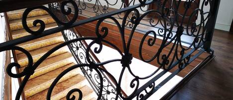 A staircase with ornate black metal railings and wooden steps.