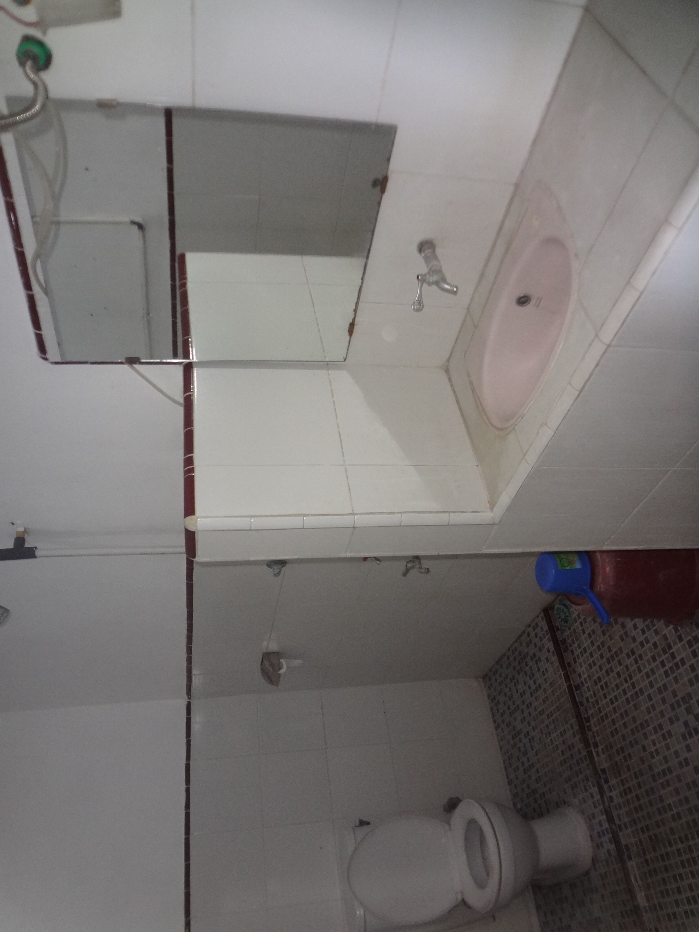 Ein Badezimmer mit Waschbecken, Spiegel und Toilette.