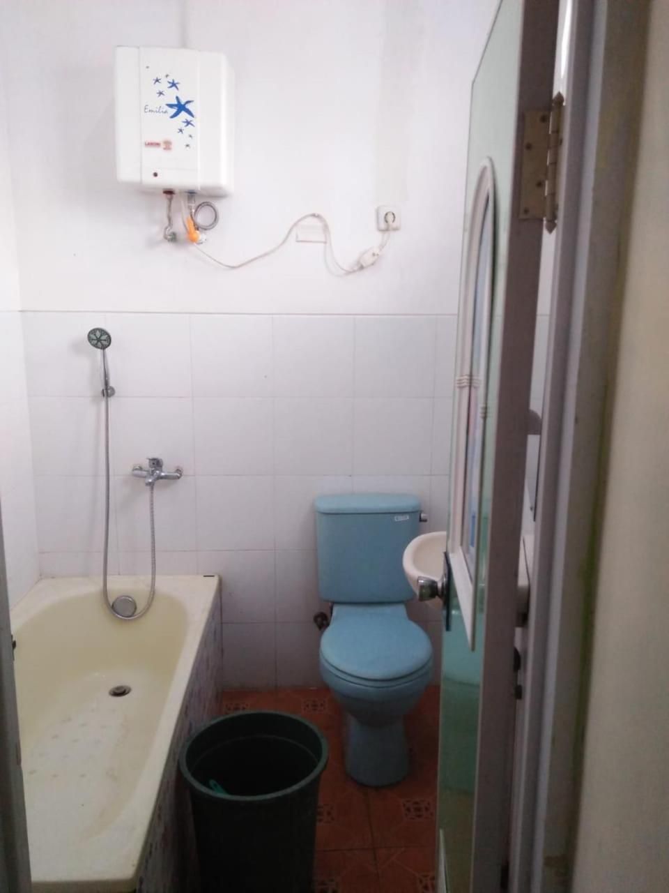 A small bathroom with a toilet, a shower, and a sink.