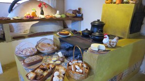 A kitchen area with a wood-fired oven, various food items, and kitchen utensils. - Praia da Crioula (Vargem Bonita)