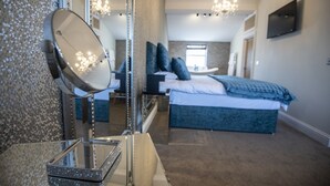 A bedroom with a large bed, a bedside table, a mirror, and a chandelier. - George Wright Boutique Hotel, Bar & Restaurant. (Rotherham)