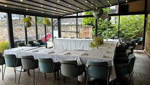 A covered outdoor dining area with tables set for a meal, surrounded by chairs, and decorated with balloons. - George Wright Boutique Hotel, Bar & Restaurant. (Rotherham)