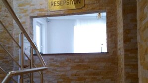 Una escalera conduce a una habitación con la leyenda "RESEPSIYON", visible una ventana y una puerta en la parte superior.