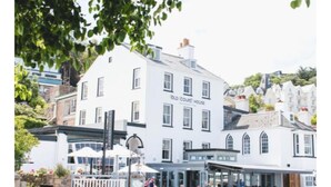 A white building with the sign "Old Court House" on the side, surrounded by other buildings and greenery. - The Old Courthouse Inn (St. Brelade)