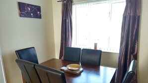 Un comedor con una mesa de madera y seis sillas.