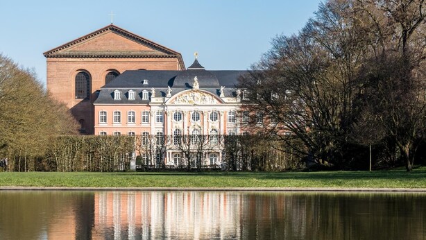 A large building with a prominent central section and a smaller brick structure to the left. - Hotel Haus am Berg (Trier)