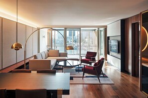 A modern living room with a sofa, red armchair, and a round coffee table. - Park Hyatt Auckland (Auckland)