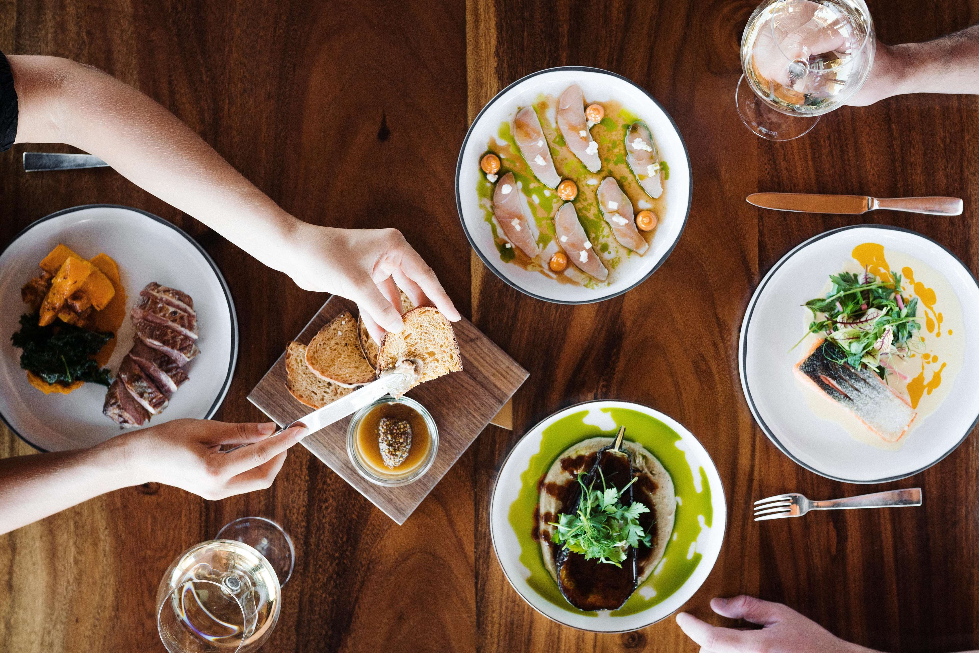 A dining table with various dishes and utensils.