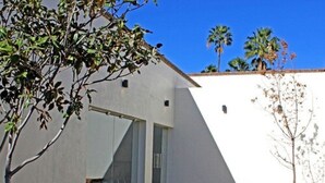A modern house with a patio, a bench, and a tree. - Hotel Sand's San Luis Potosí (San Luis Potosi)