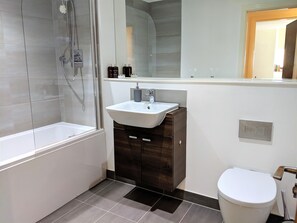 Ein modernes Badezimmer mit Badewanne, Waschbecken und Toilette.