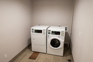 A laundry room with two stacked appliances, one dryer and one washer, with digital displays. - Holiday Inn Express & Suites Fort Wayne North by IHG (Fort Wayne)