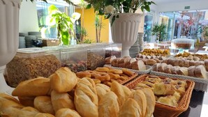 A buffet with various baked goods including bread, pastries, and cookies.
