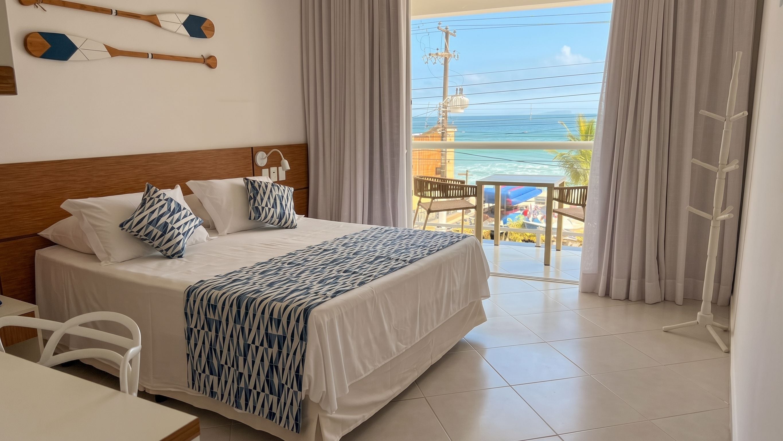 Ein Hotelzimmer mit Bett, Schreibtisch und Meerblick.