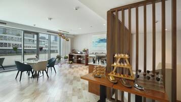 A modern dining area with a wooden table, chairs, and a display of pastries.
