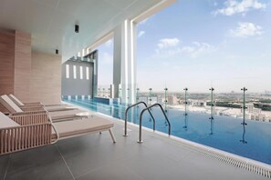 Una piscina al aire libre, tumbonas