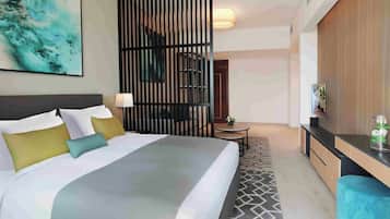 Une chambre d’hôtel moderne équipée d’un grand lit, d’un bureau, d’une chaise et d’un paravent décoratif.
