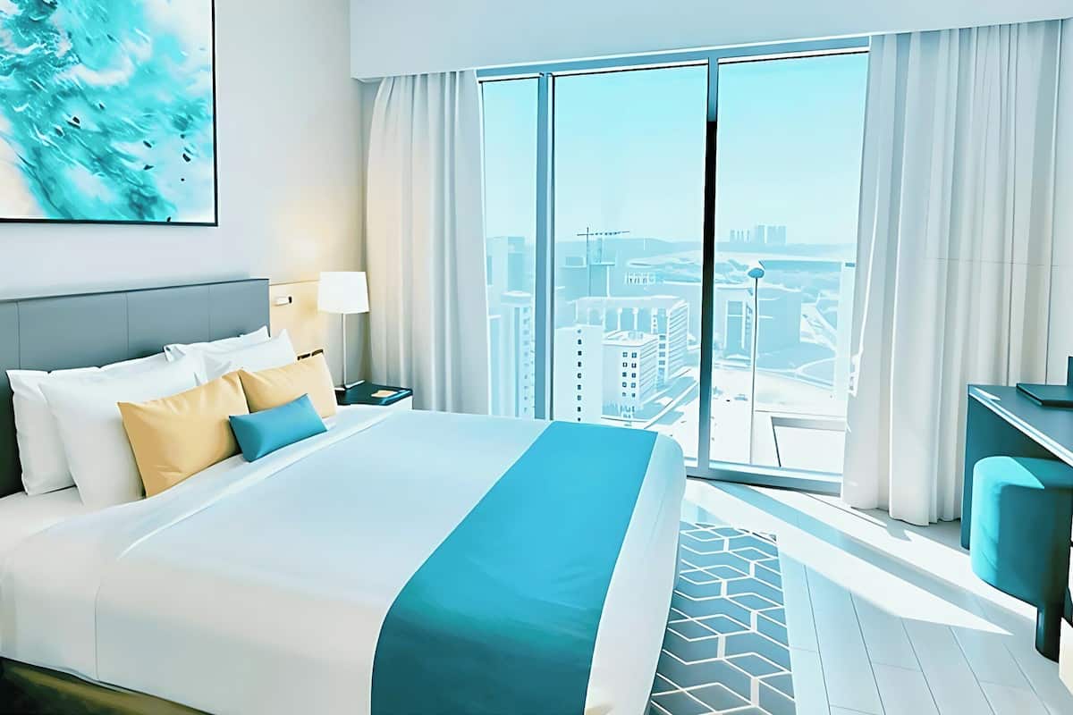 Ein Hotelzimmer mit einem großen Bett, Blick auf die Stadt und modernem Design.