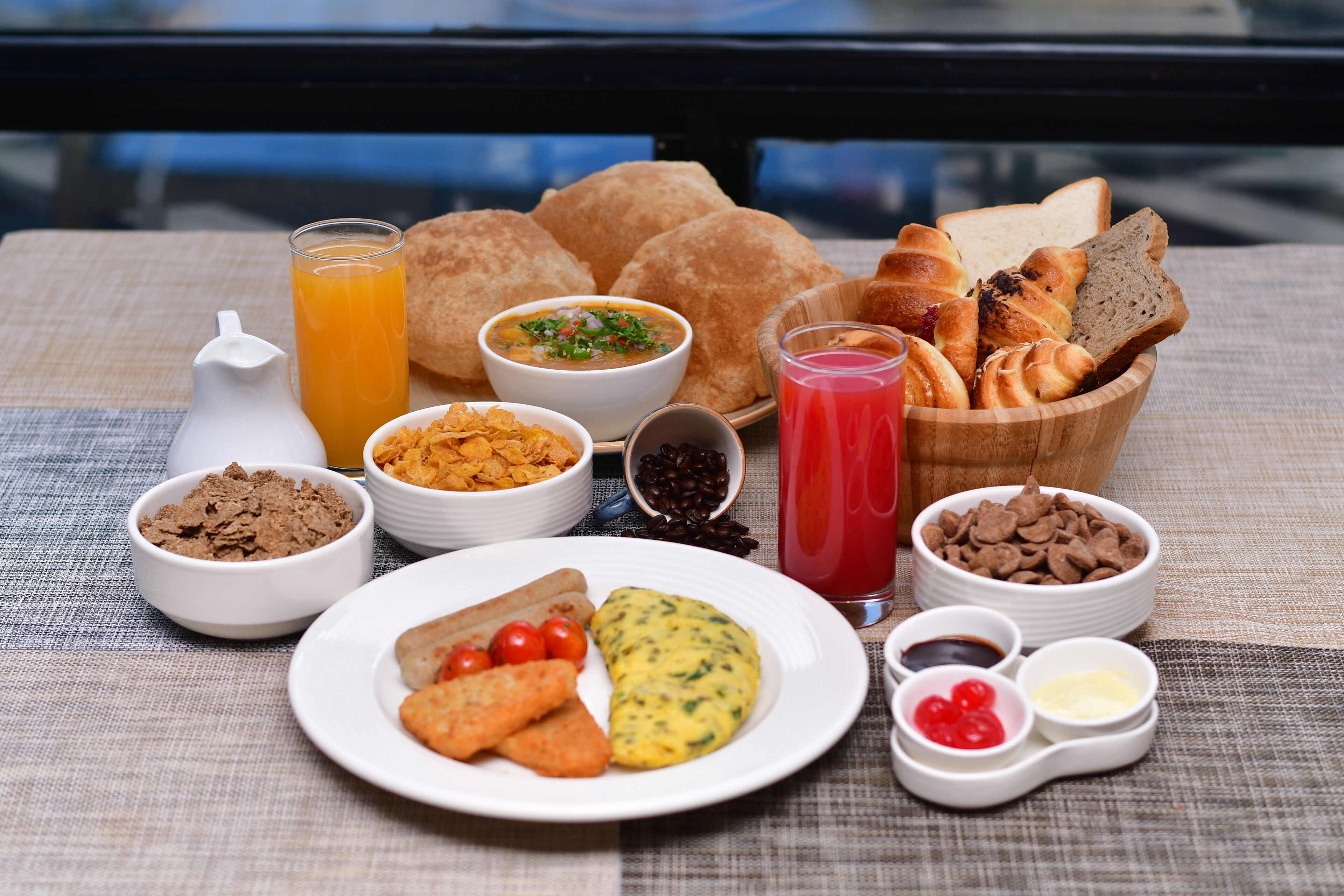 A breakfast spread with various dishes, including toast, cereal, eggs, and juice.