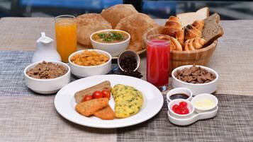A breakfast spread with various dishes, including toast, cereal, eggs, and juice.
