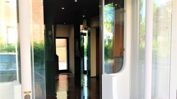 A modern building entrance with glass doors, a polished floor, and a clear view into the interior. - Hotel Dozza (Dozza)