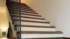 A wooden staircase with a black railing, leading to a landing. - Hotel Dozza (Dozza)