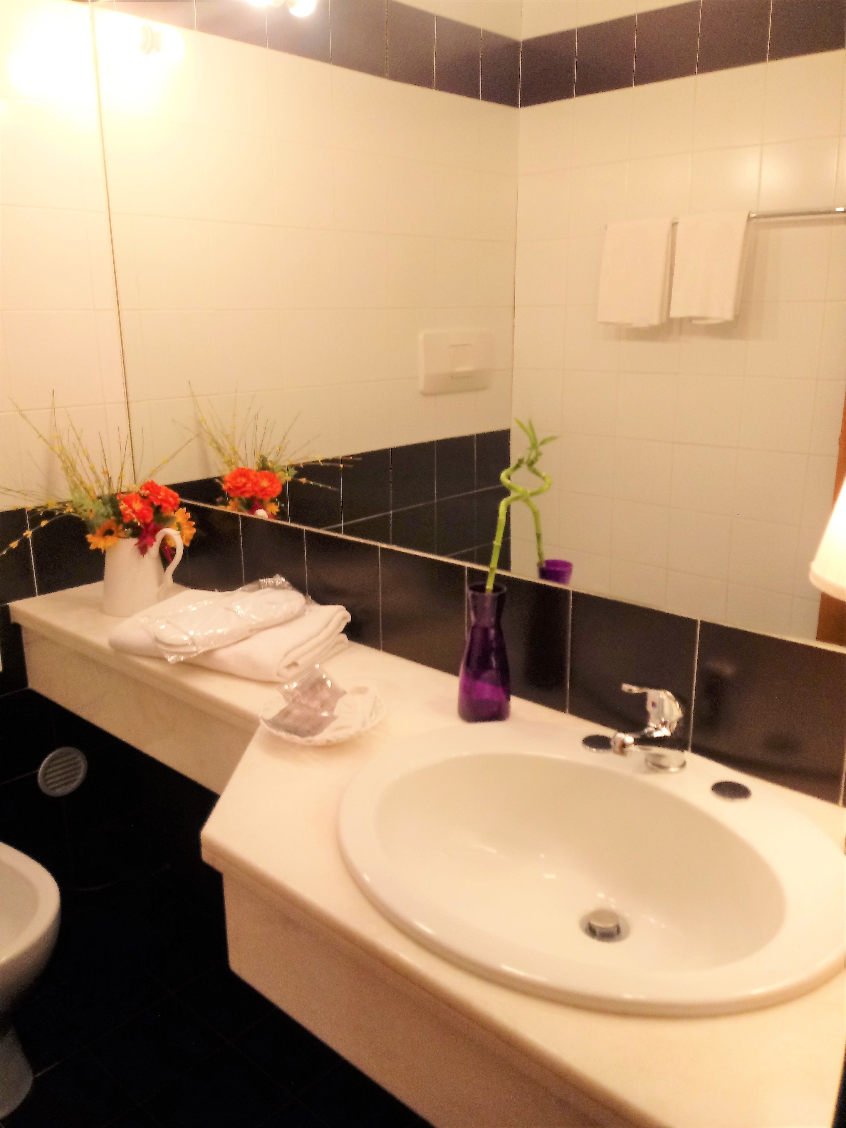 A bathroom with a white sink, a mirror, and a towel rack.