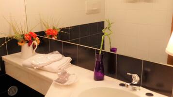 A bathroom with a white sink, a mirror, and a towel rack.