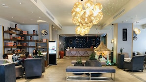 Un vestíbulo moderno con mostrador de recepción, zona de estar e iluminación decorativa.