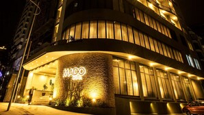 Un hotel de varios pisos con fachada curva, iluminado por luces exteriores.