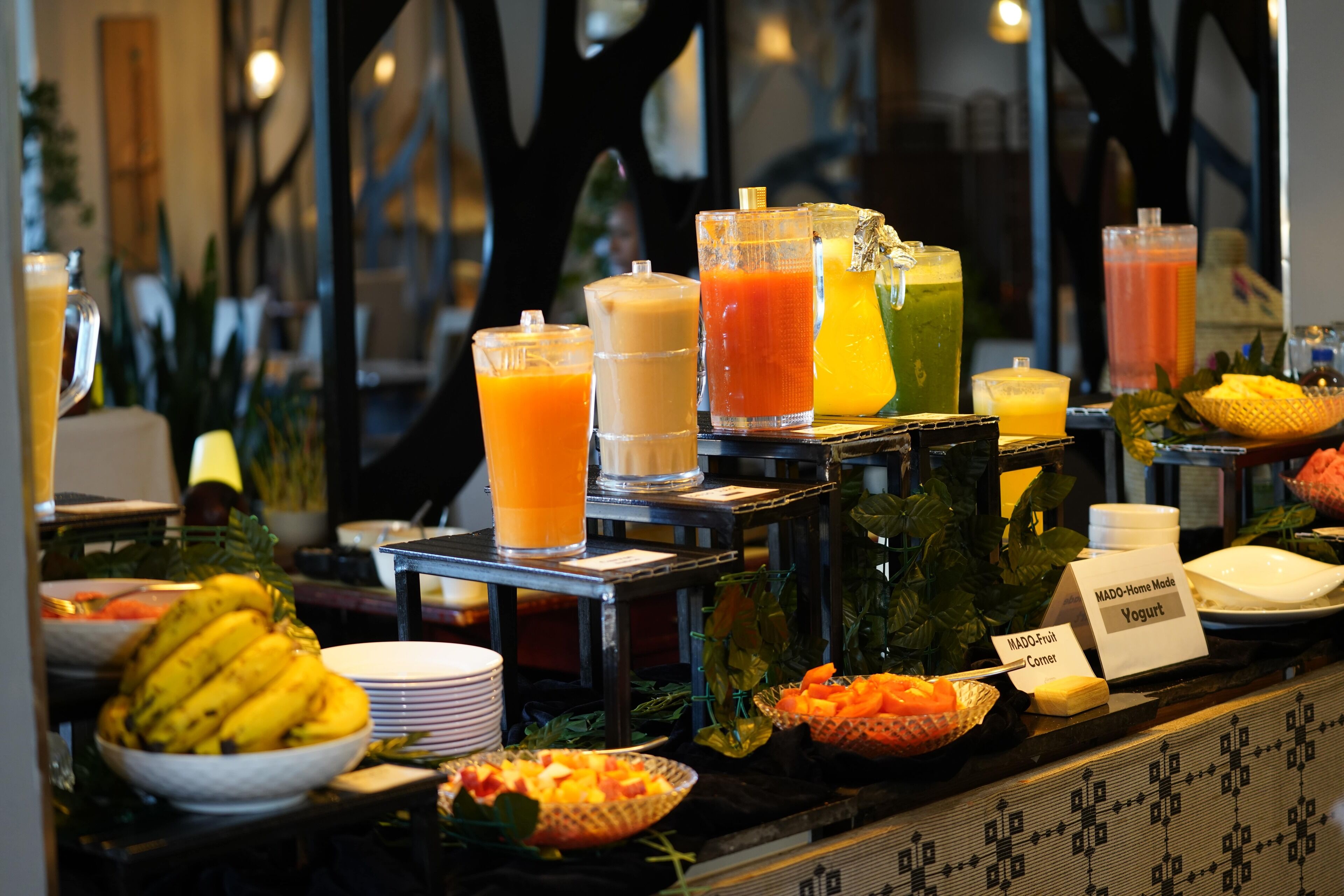 A buffet with various food and drink options, including fruits, vegetables, and different types of juices.