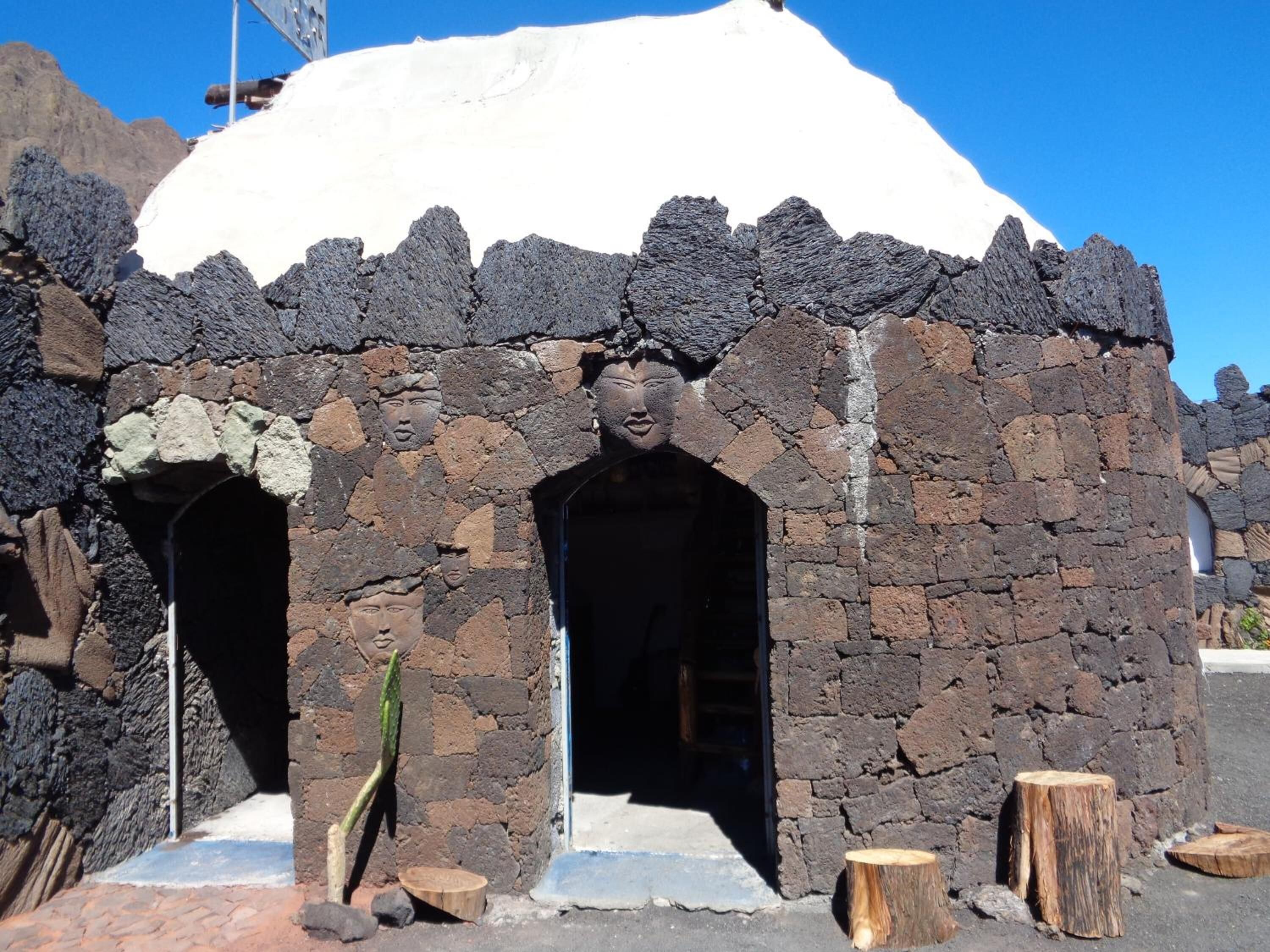 A stone structure with two arched openings and a snow-covered roof.