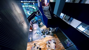Un interno moderno con una scala a chiocciola, un'area di lavoro open space e ampie finestre.
