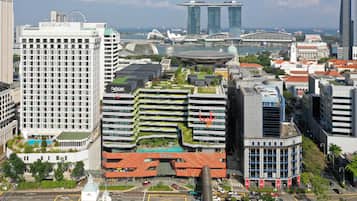 A modern hotel with a curved roof, multiple floors, and a prominent entrance.