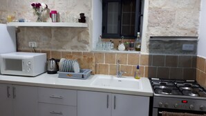 A kitchen with a microwave, sink, stove, and cabinets. - I'm Jerusalem (Jerusalem)
