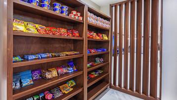 A pantry stocked with various food items including canned goods, chips, and snacks.