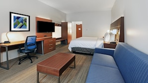 A hotel room with a bed, a desk, a chair, a sofa, a TV, and a framed picture on the wall. - Holiday Inn Express & Suites Tulsa Northeast - Owasso by IHG (Owasso)