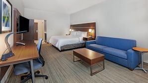 A hotel room with a bed, a sofa, a desk with a computer, and a TV. - Holiday Inn Express & Suites Tulsa Northeast - Owasso by IHG (Owasso)