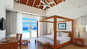 A four-poster bed with a view of the sea, a desk with a chair, and a small bedside table with a lamp. - Ocean Front Villa Deluxe 4 Bedroom (Sosúa)